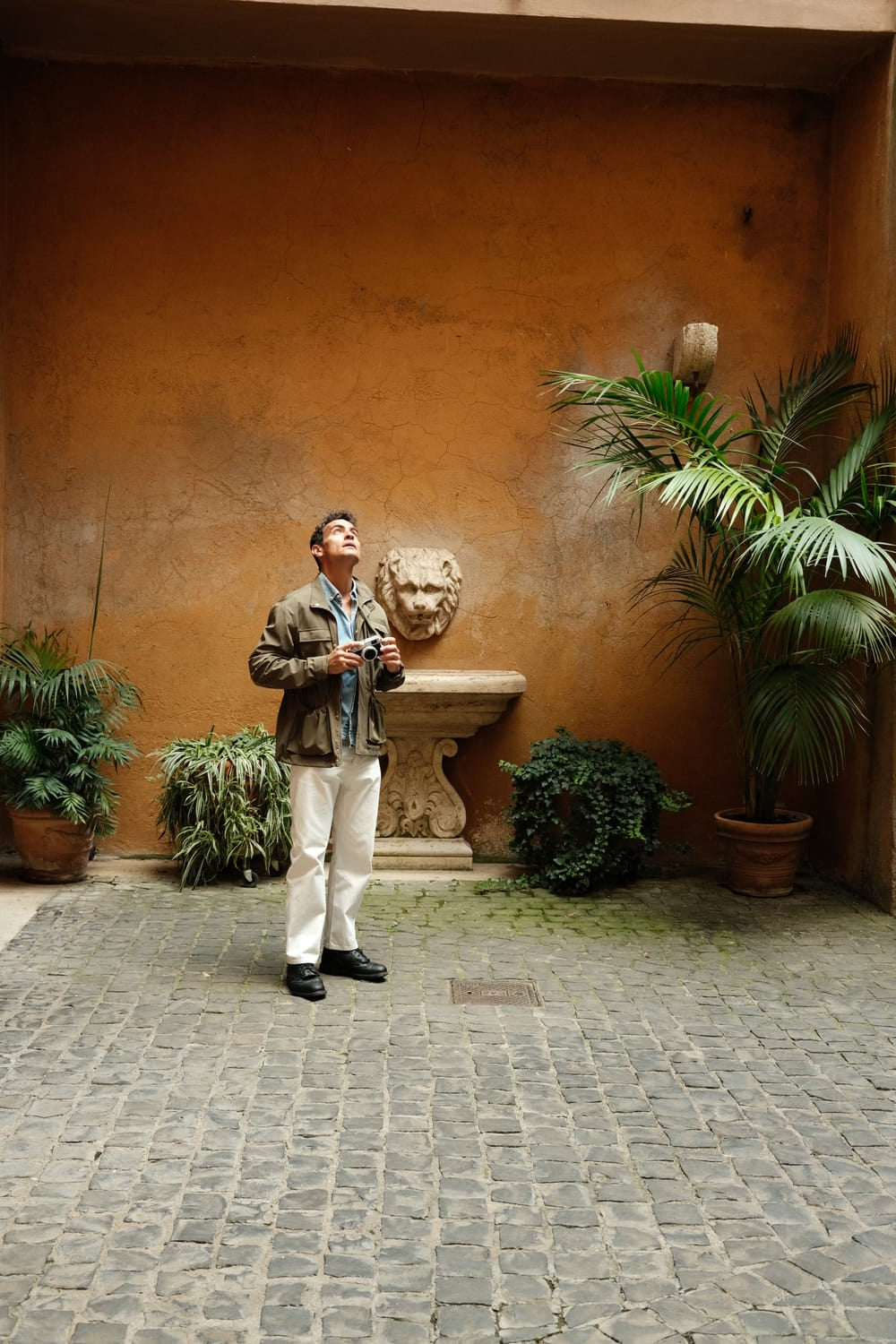 1954 Amalfi Mechanical by AV86 worn with layered casual attire in historic courtyard, evoking timeless Mediterranean elegance and exploration spirit