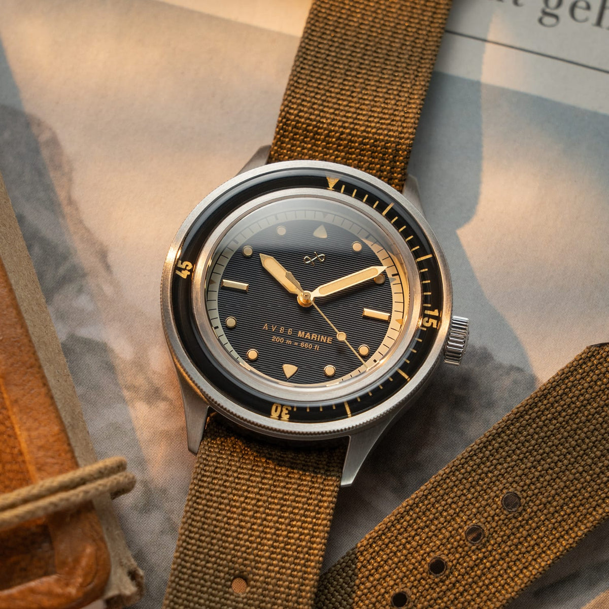 AV86 vintage-inspired diver with sapphire crystal, rotating bezel, and textured fabric strap in a warm light setting
