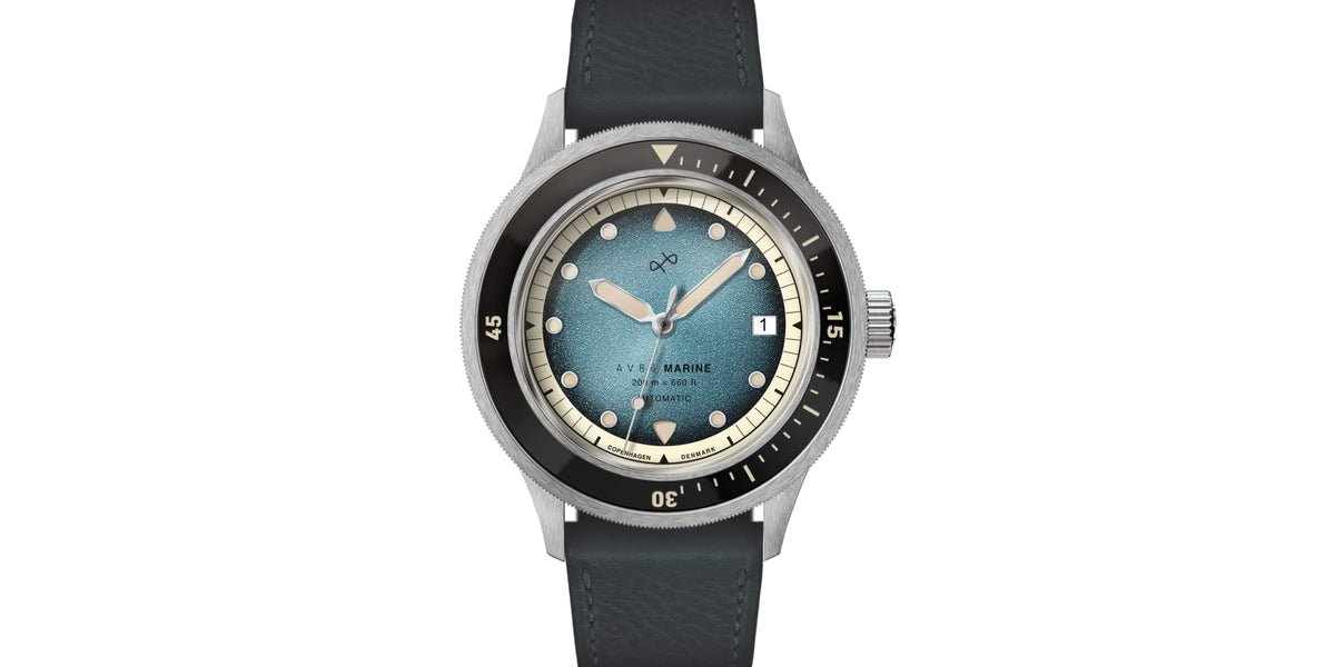 Wristwatch with a textured blue dial, black rotating bezel, and polished steel case paired with a black leather strap.