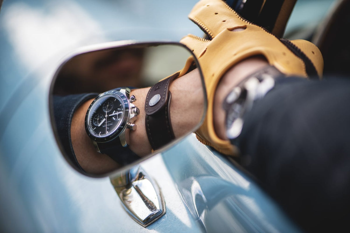 1960 Racing Chronograph by AV86 vintage-inspired chronograph with sapphire crystal and black leather strap reflecting in classic car mirror