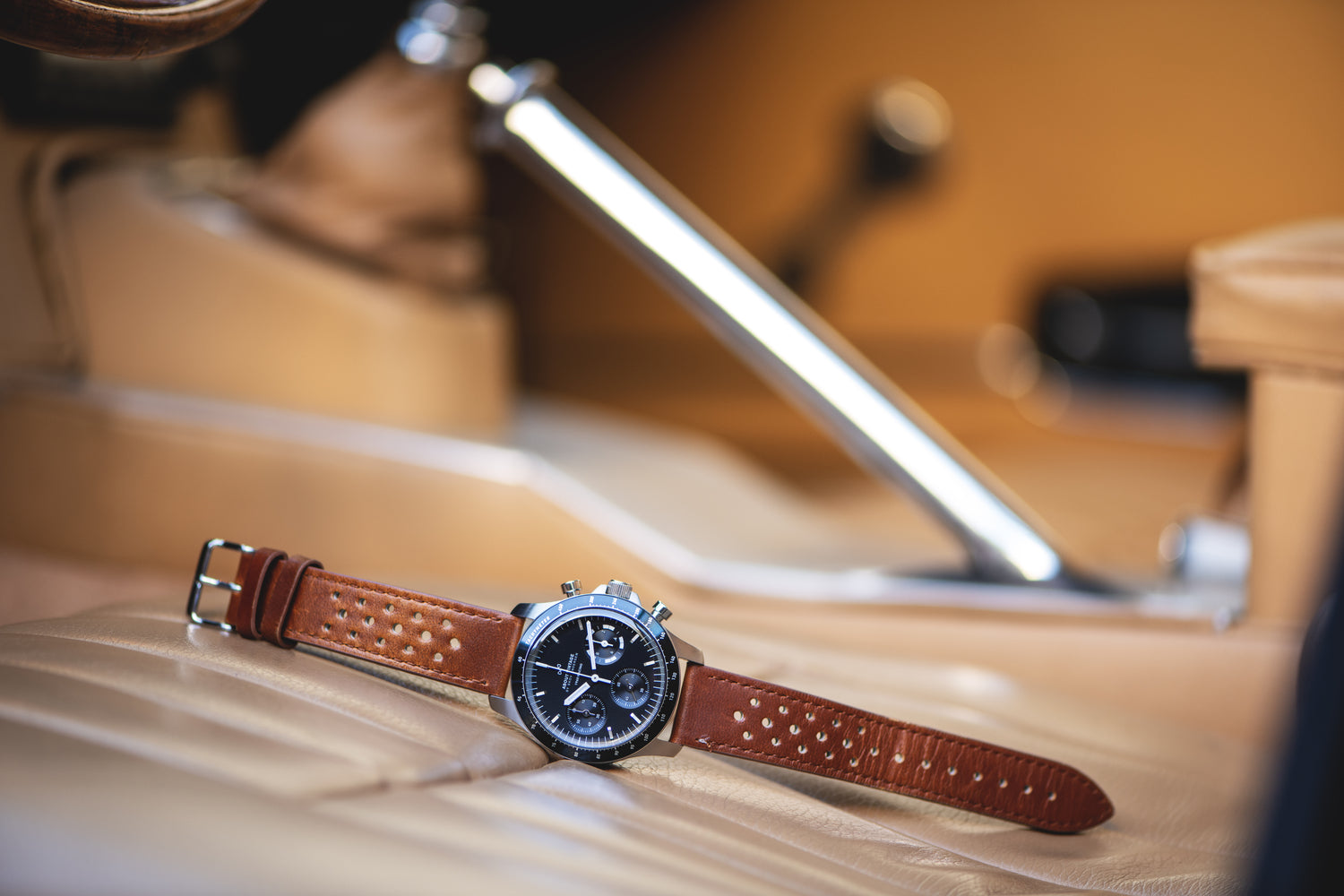 1960 Racing Chronograph by AV86 vintage-inspired chronograph with sapphire crystal and perforated brown leather strap on car seat