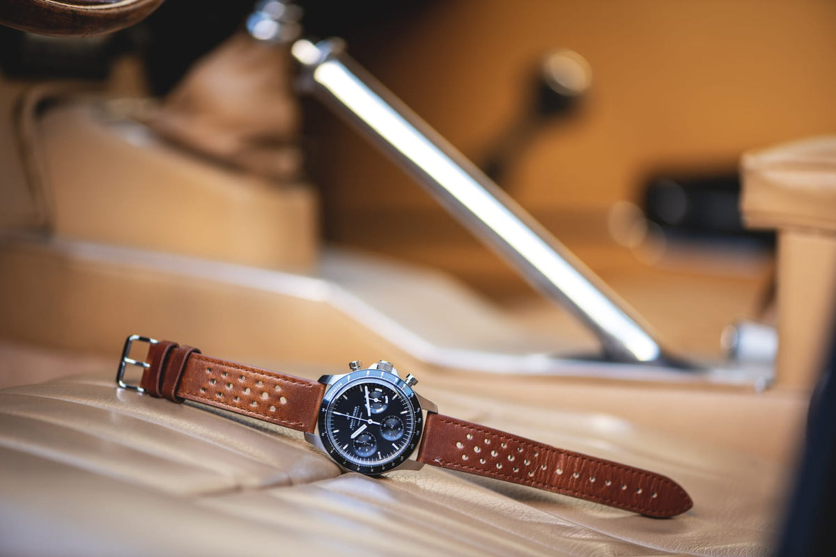 1960 Racing Chronograph by AV86 vintage-inspired chronograph with sapphire crystal and perforated brown leather strap on car seat