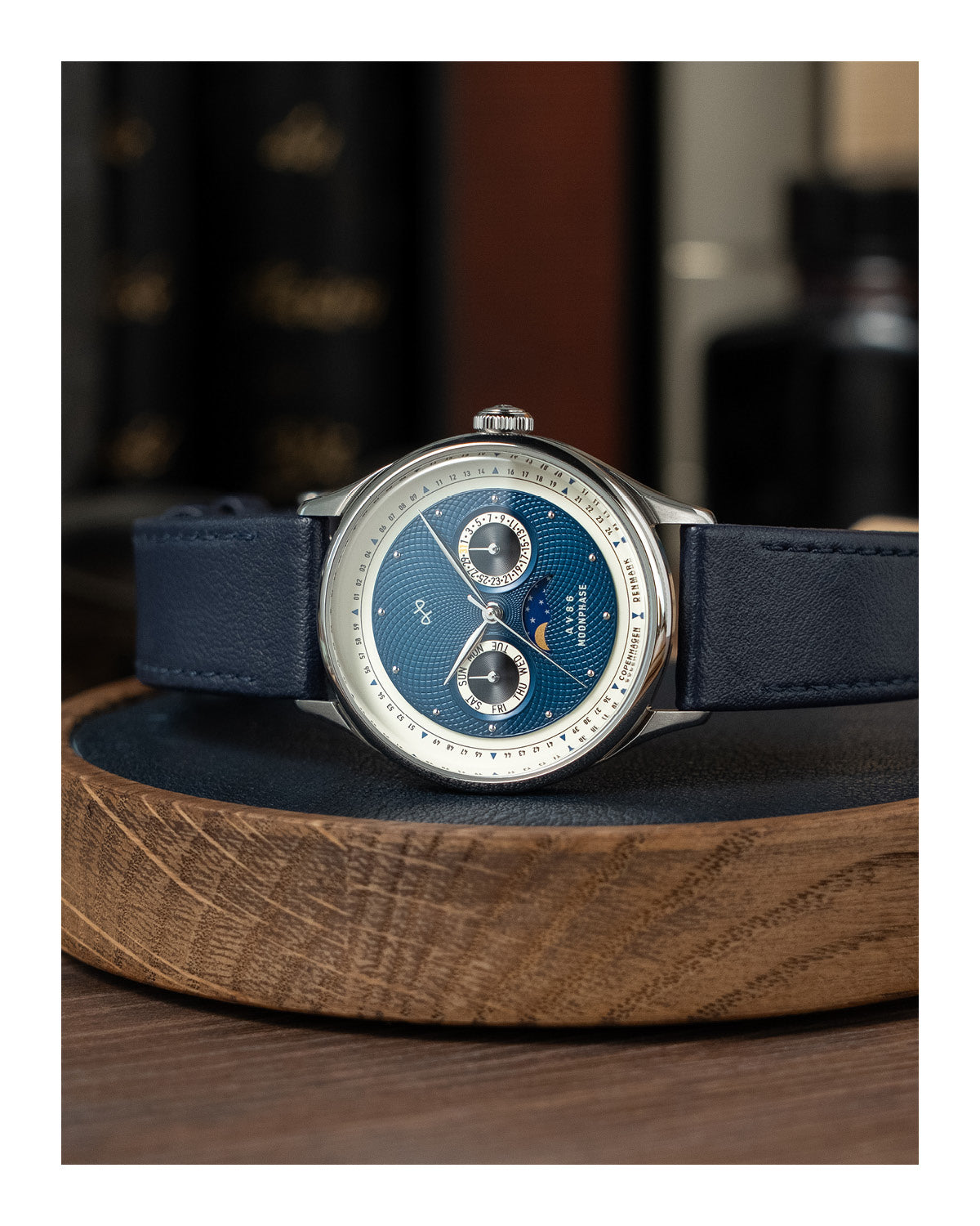 AV86 vintage-inspired moonphase watch with sapphire crystal, textured dial, polished bezel, and leather strap placed on wooden tray