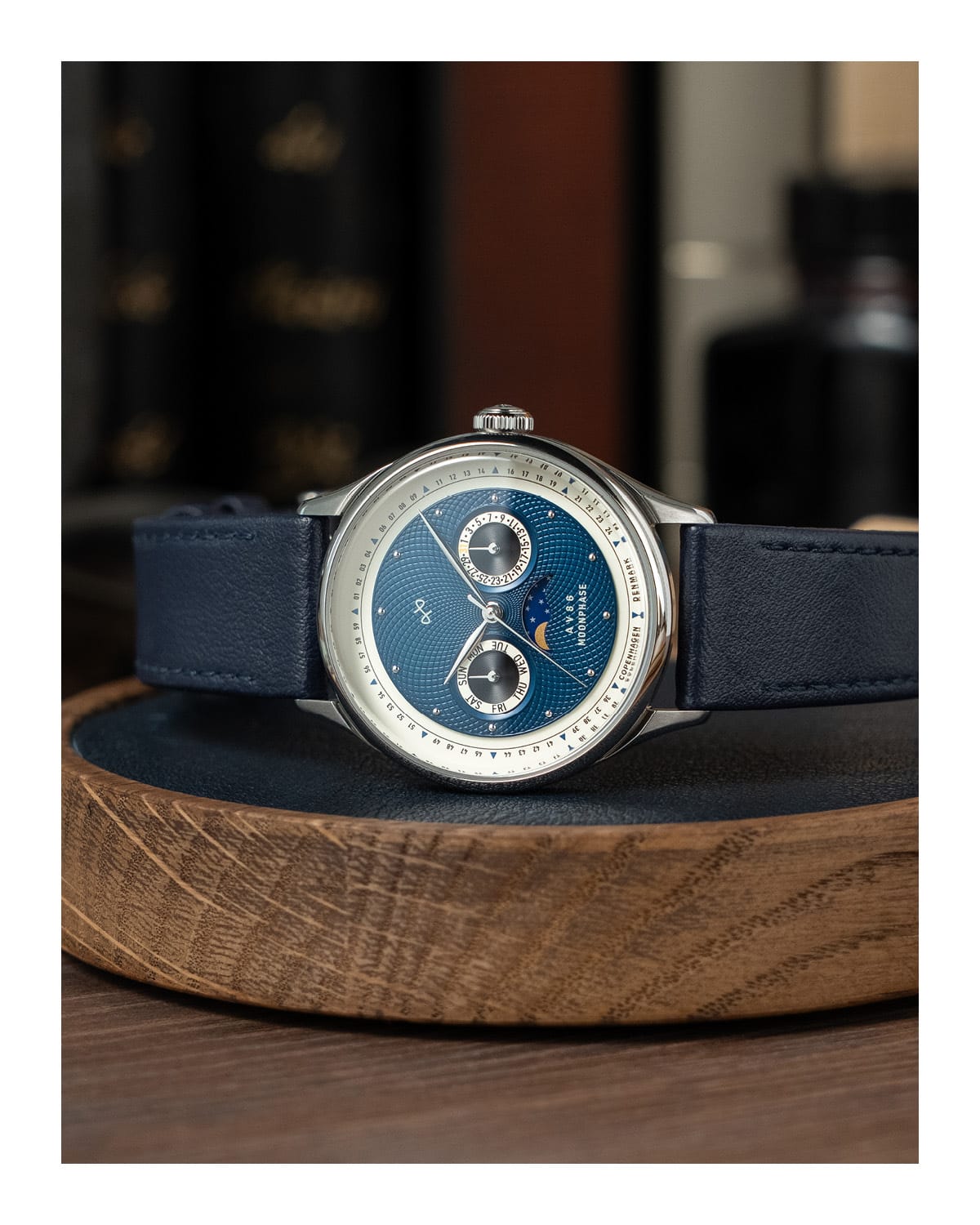 AV86 vintage-inspired moonphase watch with sapphire crystal, textured dial, polished bezel, and leather strap placed on wooden tray