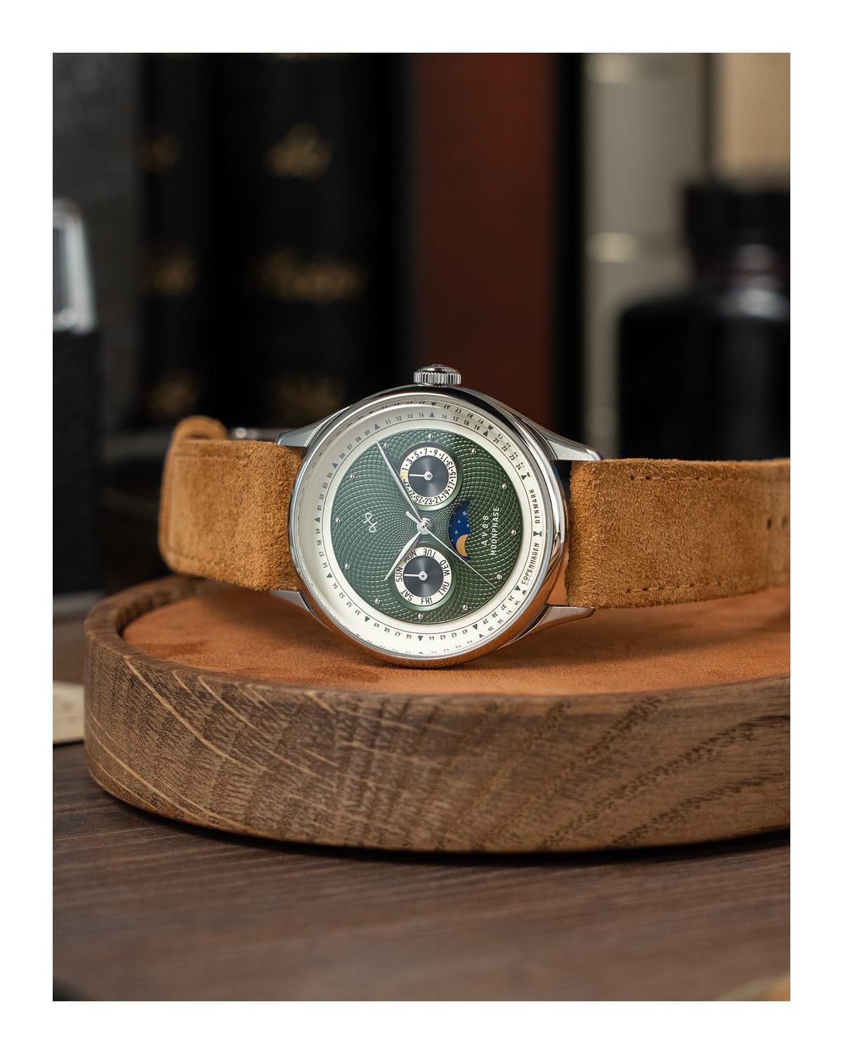 AV86 luxury moonphase watch with vintage-inspired dial, sapphire crystal, chronograph subdials, and suede leather strap on wooden stand