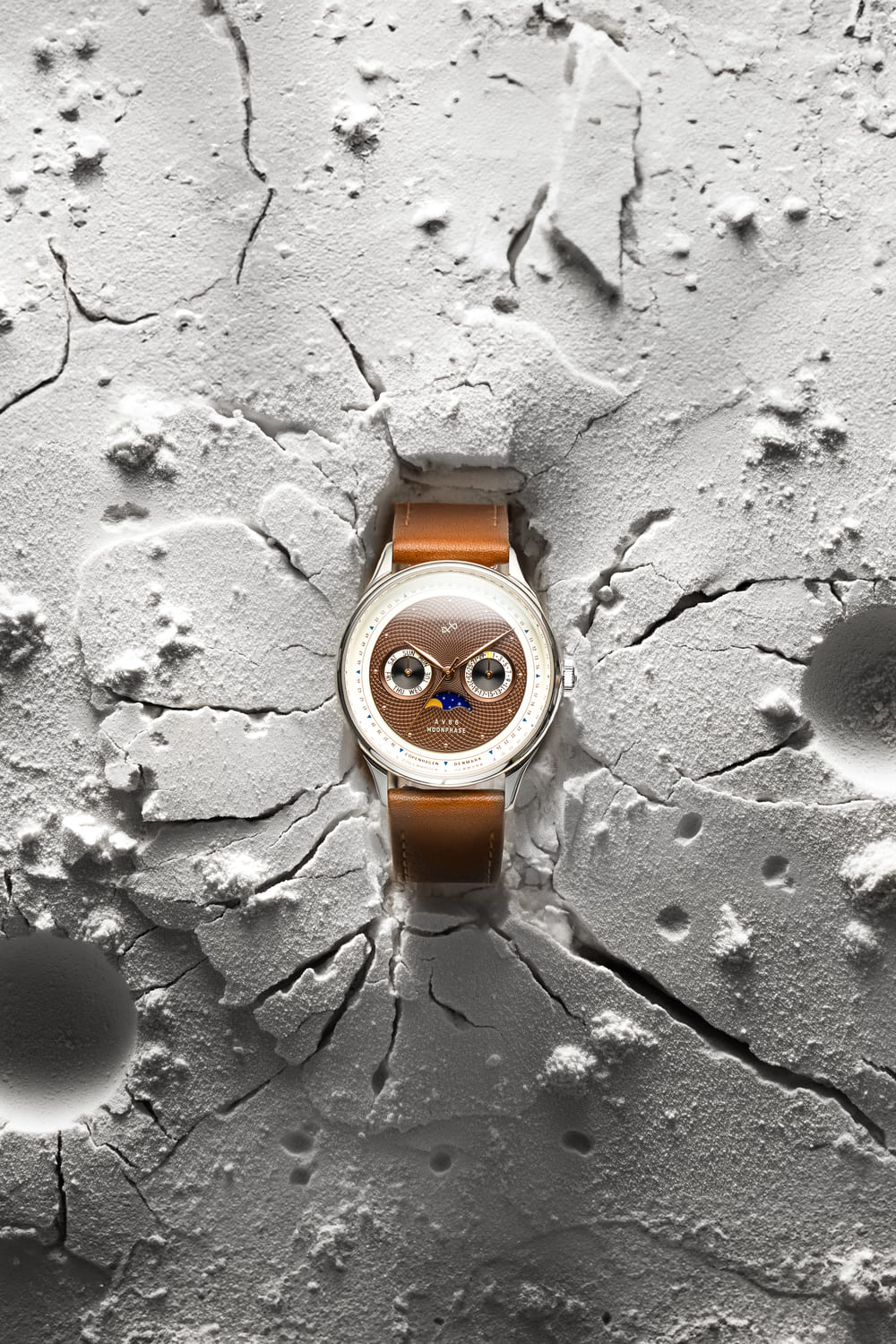 1968 Moonphase by AV86 with vintage-inspired moonphase dial, sapphire crystal, and brown leather strap on textured lunar surface