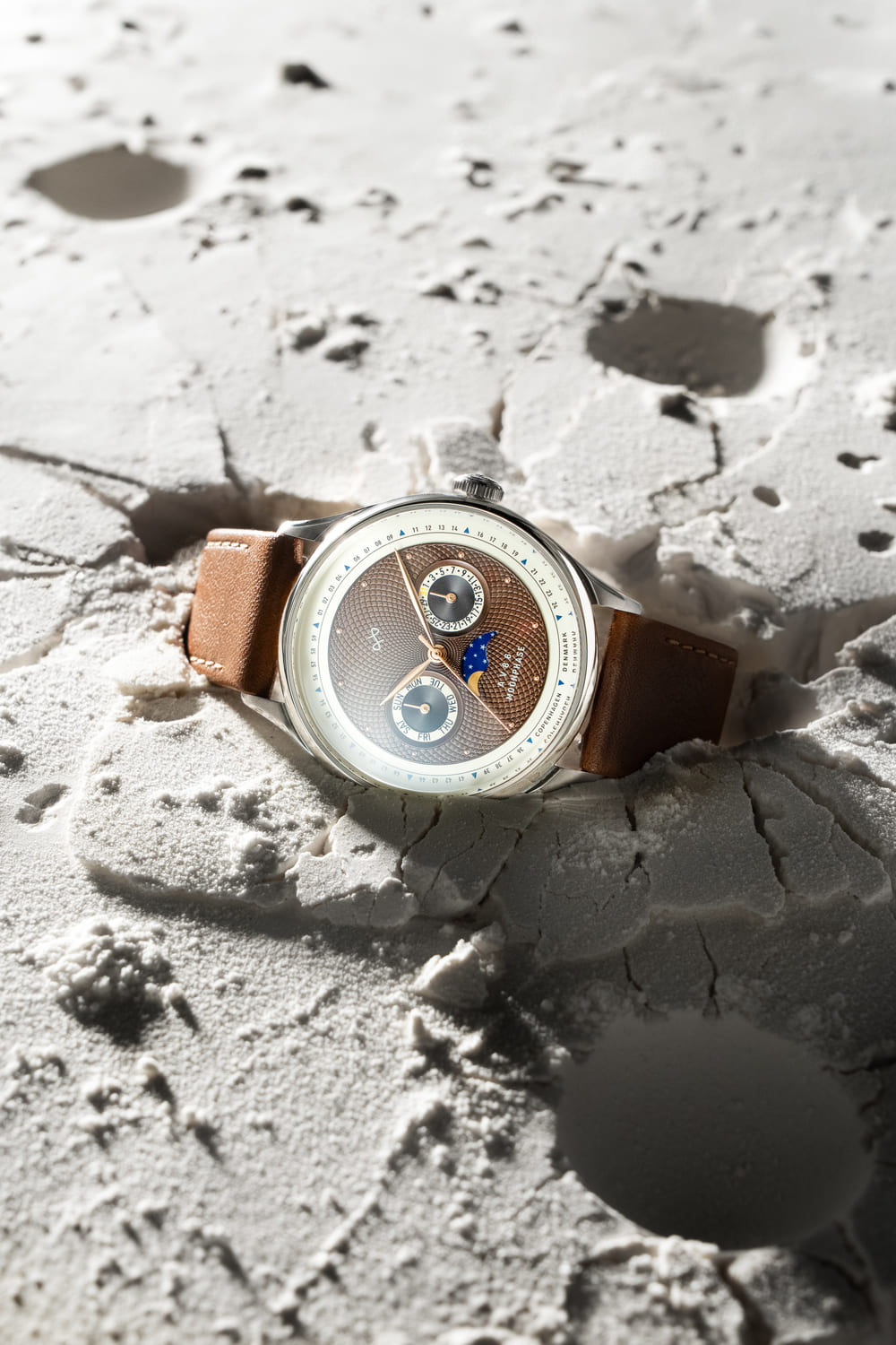 1968 Moonphase by AV86 luxury moonphase watch with sapphire crystal, textured dial, and brown leather strap on lunar surface