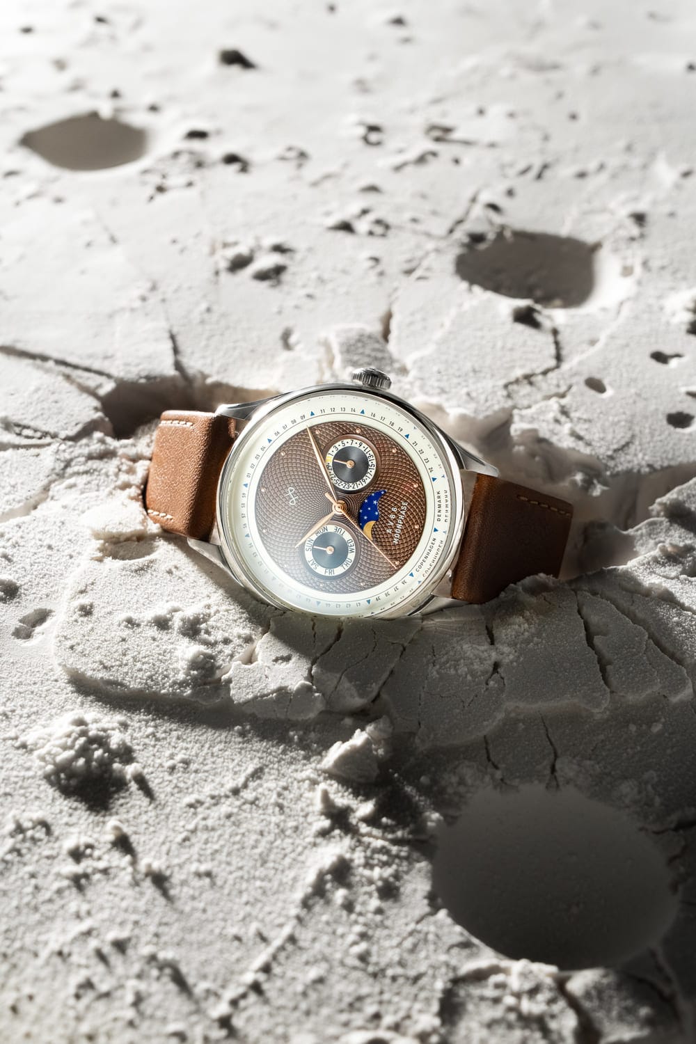 1968 Moonphase by AV86 luxury moonphase watch with sapphire crystal, textured dial, and brown leather strap on lunar surface