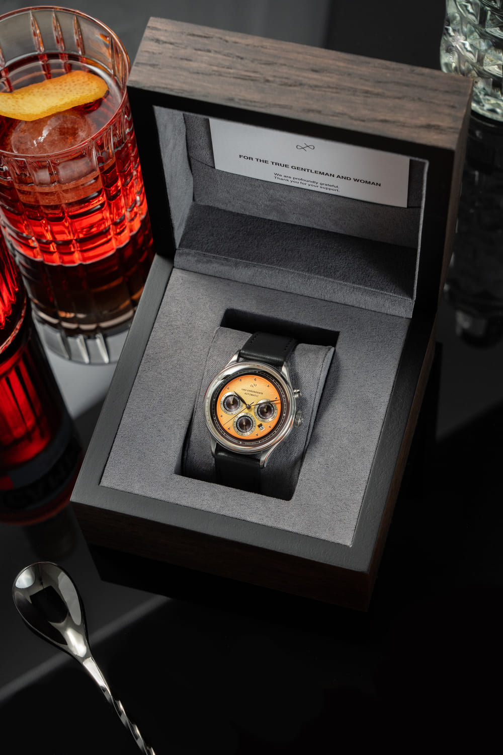 Chronodate Automatique 1564 par AV86 : chronographe d'inspiration vintage avec verre saphir, trois sous-cadranes et bracelet en cuir noir, présenté dans un coffret en bois