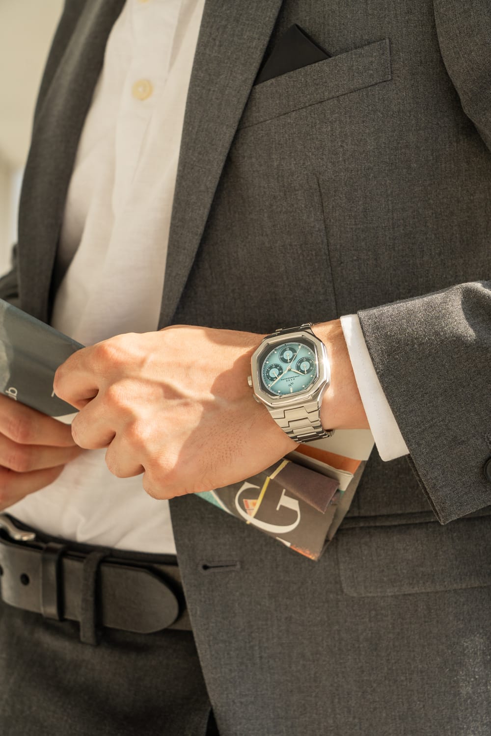 1904 Chronograph by AV86 with angular case, vintage-inspired dial, sapphire crystal, and stainless steel bracelet strap on wrist in formal attire