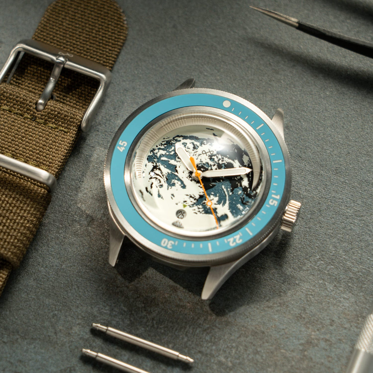 Earthrise WWF Partnership, Automatic / 2026 Edition by AV86 with blue bezel and wave dial close-up on workbench setting
