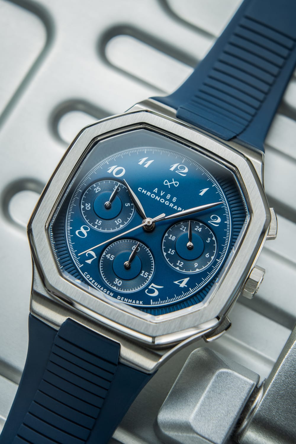 AV86製1904 Chronograph。シャープな角張りのあるケース、Sapphire Crystal、ブルーの文字盤、クロノグラフのサブダイヤル、そしてテクスチャー加工が施されたラバーストラップを備えています