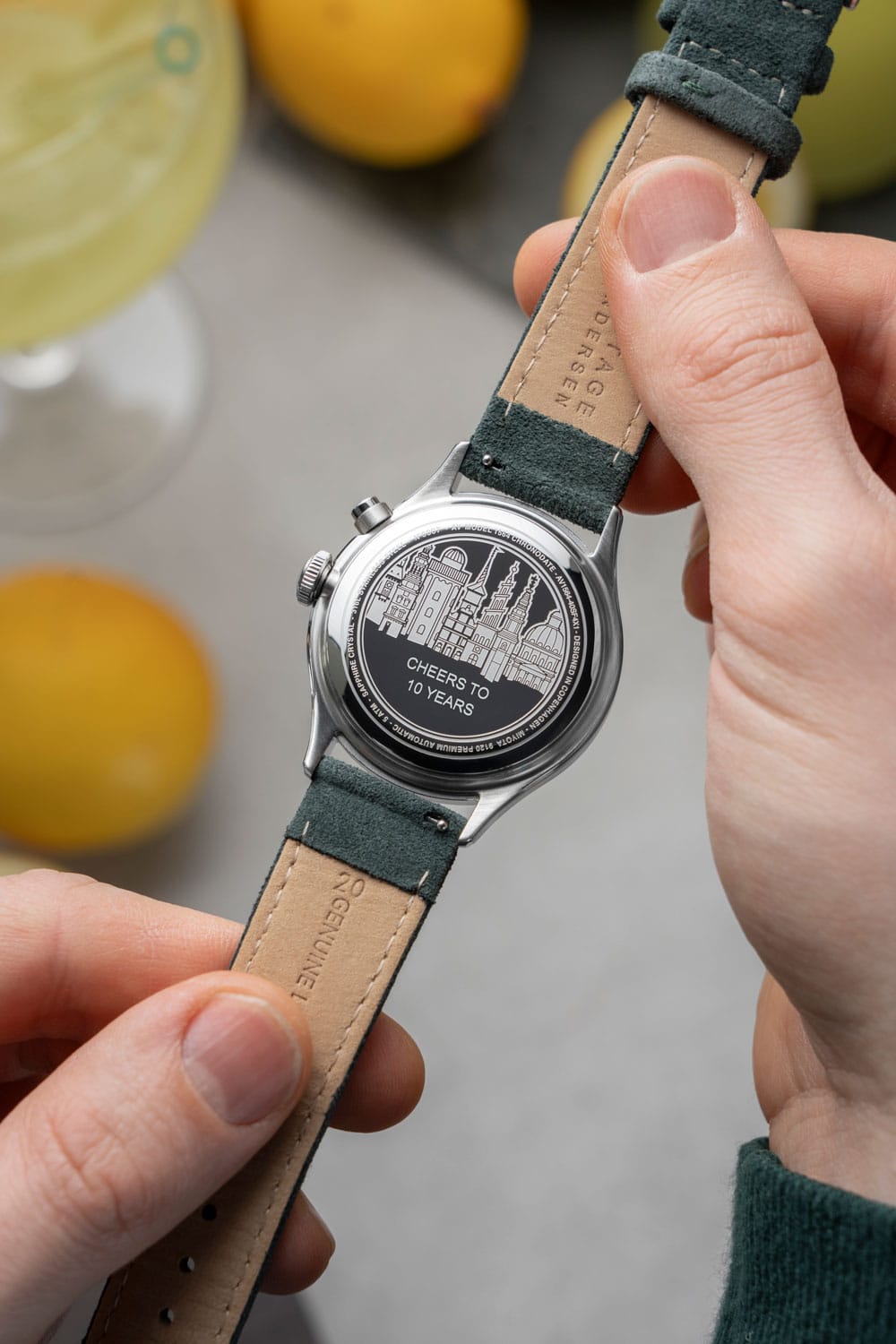 Close-up of engraving on the back of an AV86 chronograph watch celebrating 10 years with leather strap and detailed skyline design