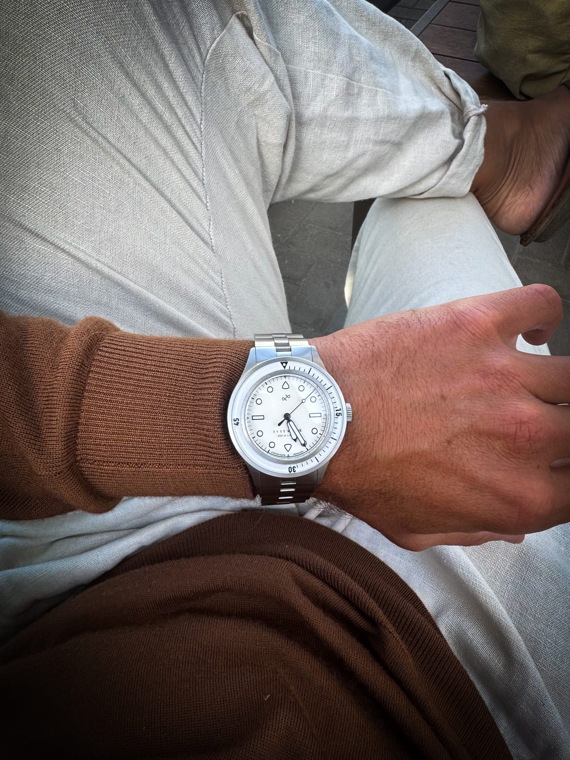 1956 Marine by AV86 vintage-inspired diver with sapphire crystal, compass bezel, and metal bracelet strap on wrist in casual setting