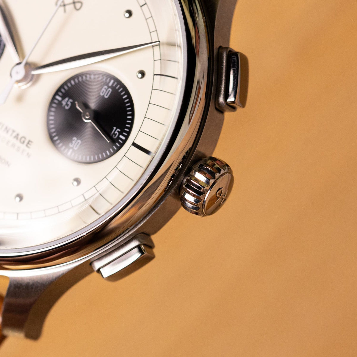 AV86 vintage inspired chronograph wristwatch close up with cream dial, black subdial, polished case, crown and leather strap