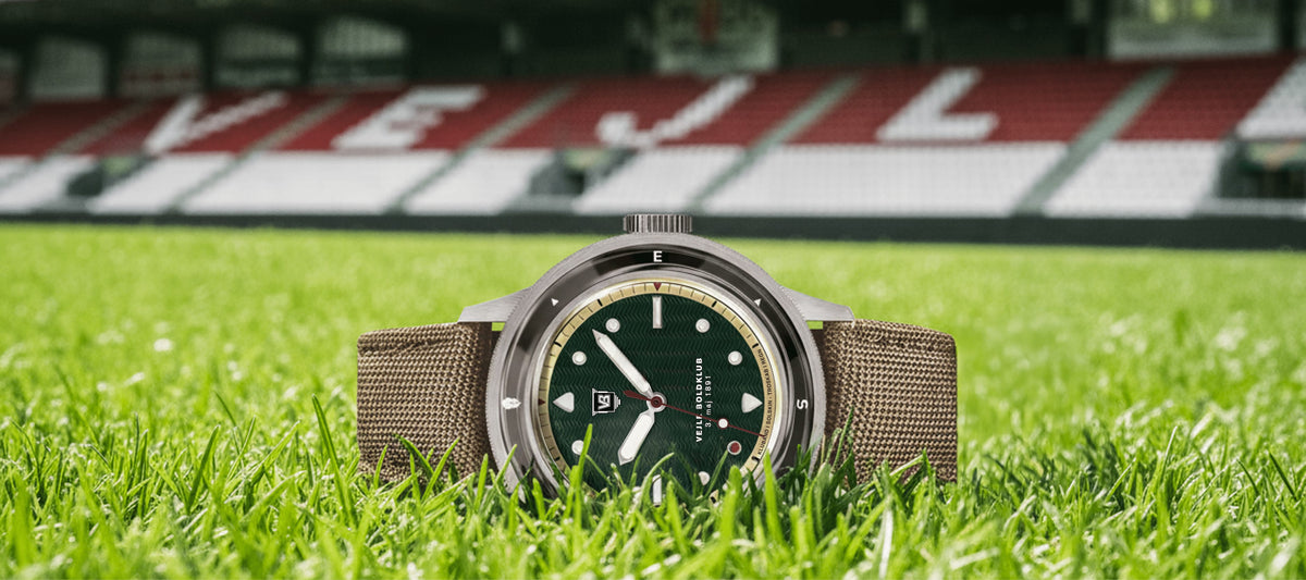 AV86 vintage-inspired diver watch with green dial, compass bezel, sapphire crystal, and textured fabric strap on grass field