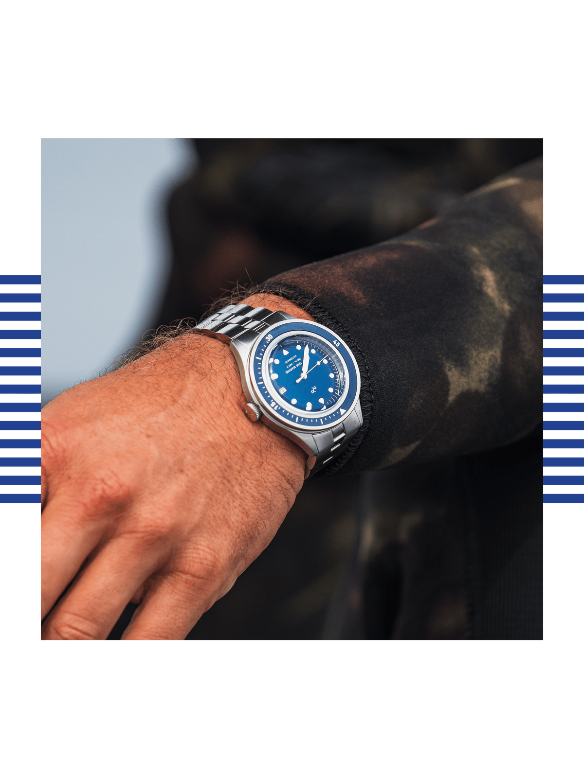 AV86 diver watch with blue dial, luminous markers, rotating bezel and linked metal bracelet worn with a dark outdoor sleeve in sunlight