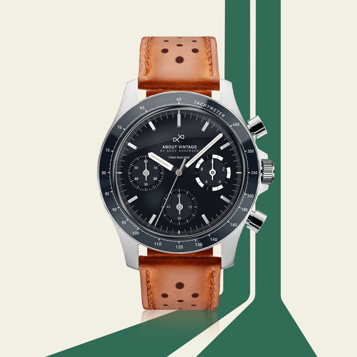 AV86 chronograph watch with black dial, three subdials, tachymeter bezel, polished case and perforated brown leather strap against a geometric backdrop