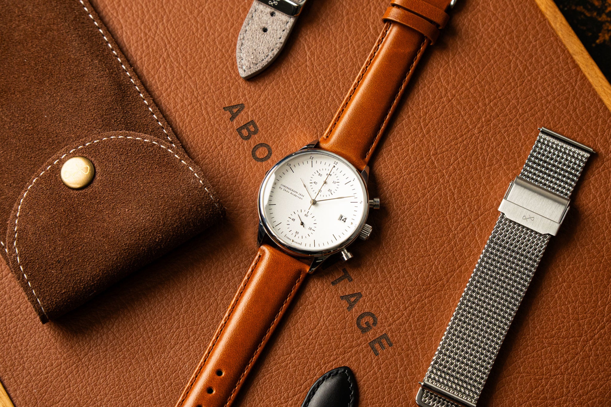 1844 Chronograph by AV86 luxury timepiece with vintage-inspired dial, sapphire crystal, and brown leather strap on a leather surface