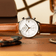 1834 Chronograph by AV86 with vintage-inspired dial, sapphire crystal, chronograph function, and brown leather strap on warm wood surface