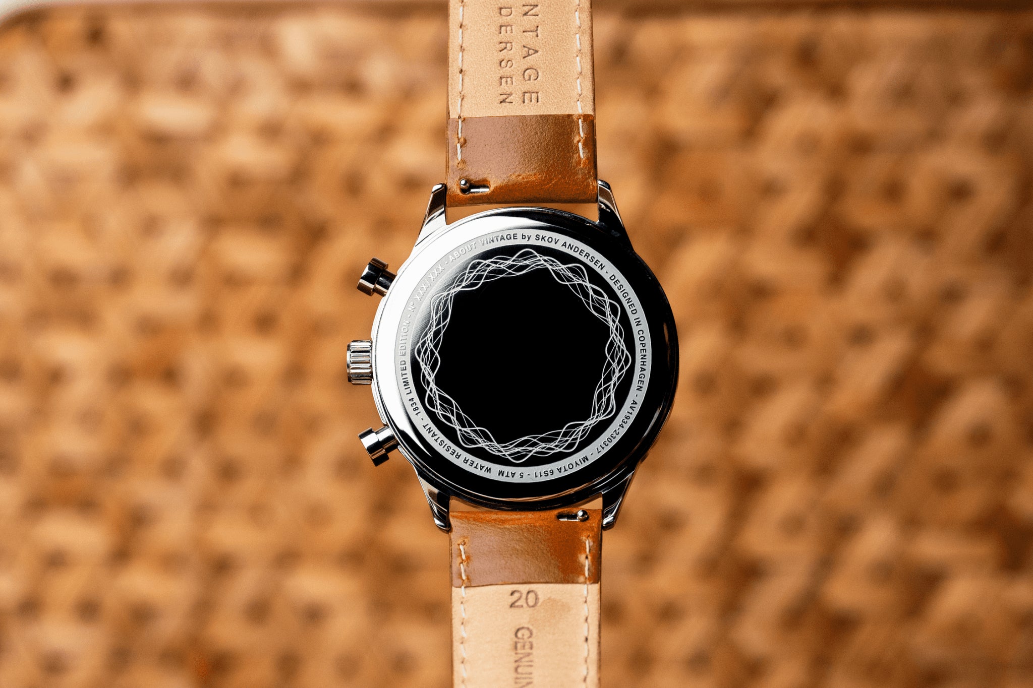 1834 Chronograph by AV86 showcasing polished case back with engraved pattern and tan genuine leather strap