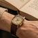 1954 Amalfi Mechanical by AV86 with polished cushion case, vintage off-white dial, small seconds, and textured leather strap worn reading book