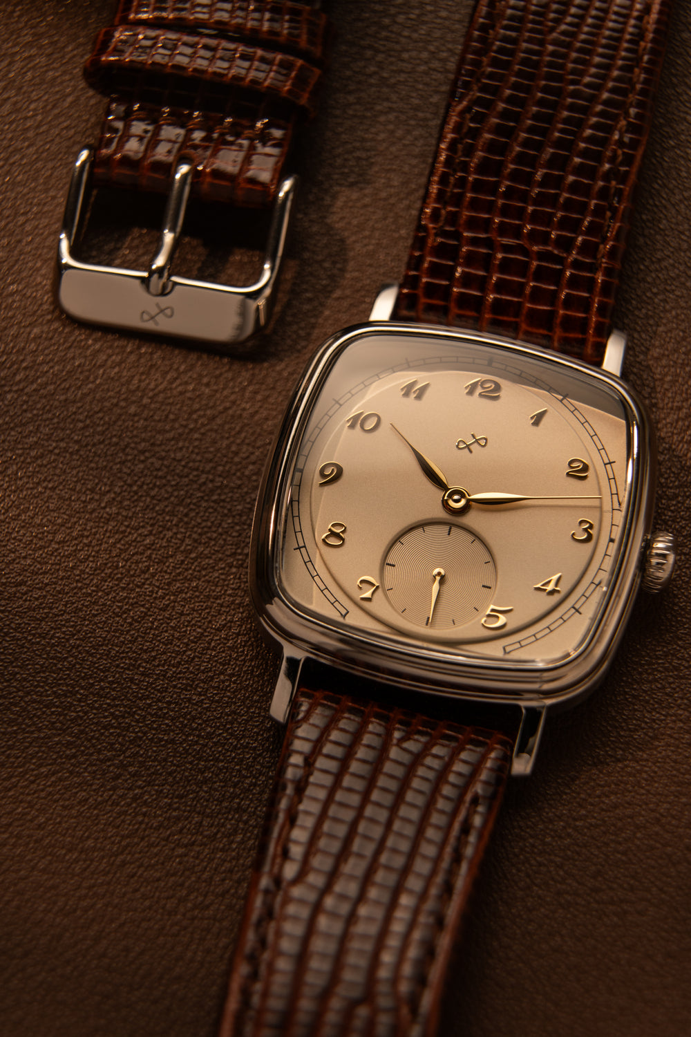 1954 Amalfi Mechanical, Steel / Off White watch by AV86 with vintage-inspired dial and brown leather strap on brown background
