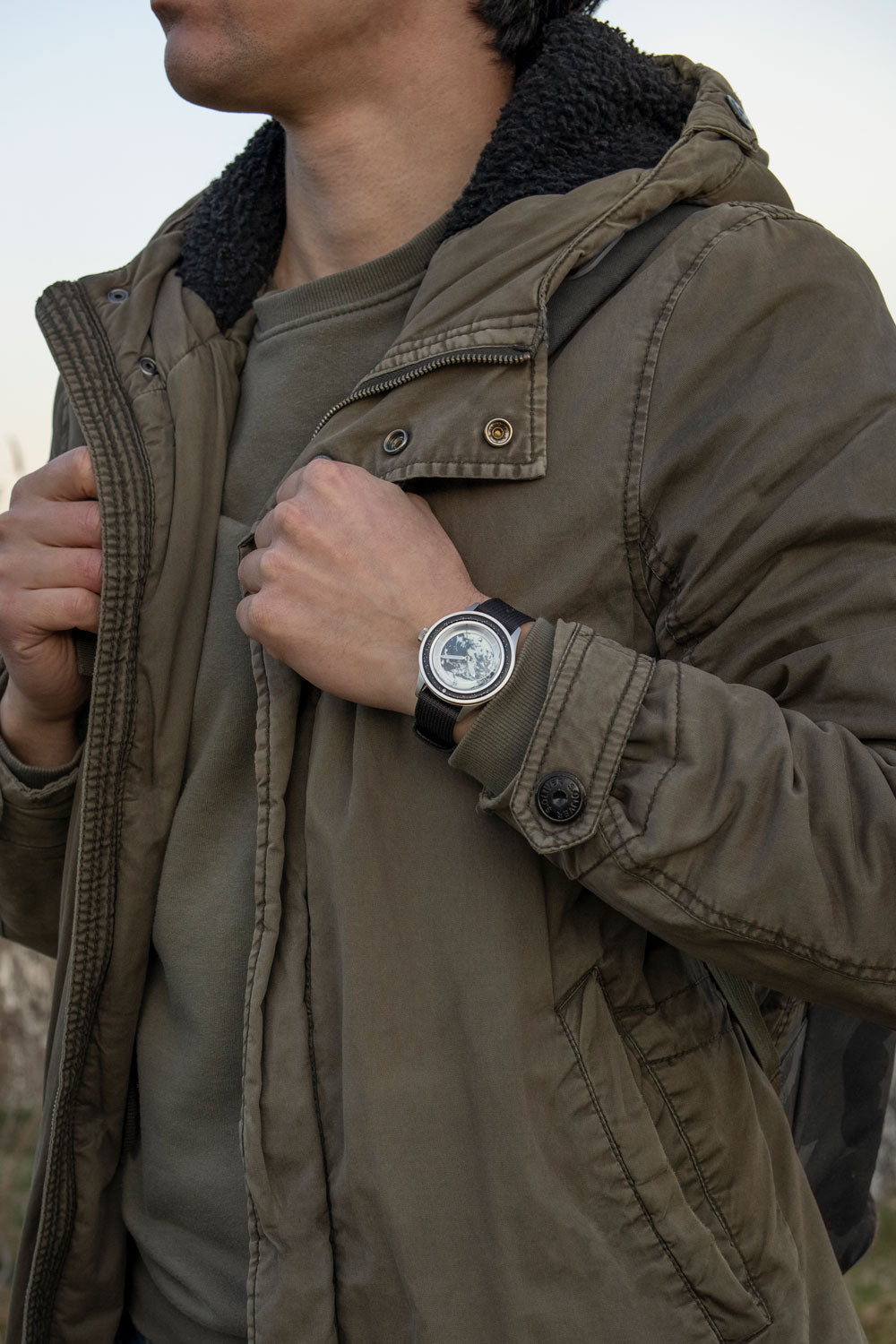 Earthrise WWF Partnership, Automatic / 2025 Edition by AV86 with Earth-inspired dial, sapphire crystal, and black leather strap on wrist outdoors