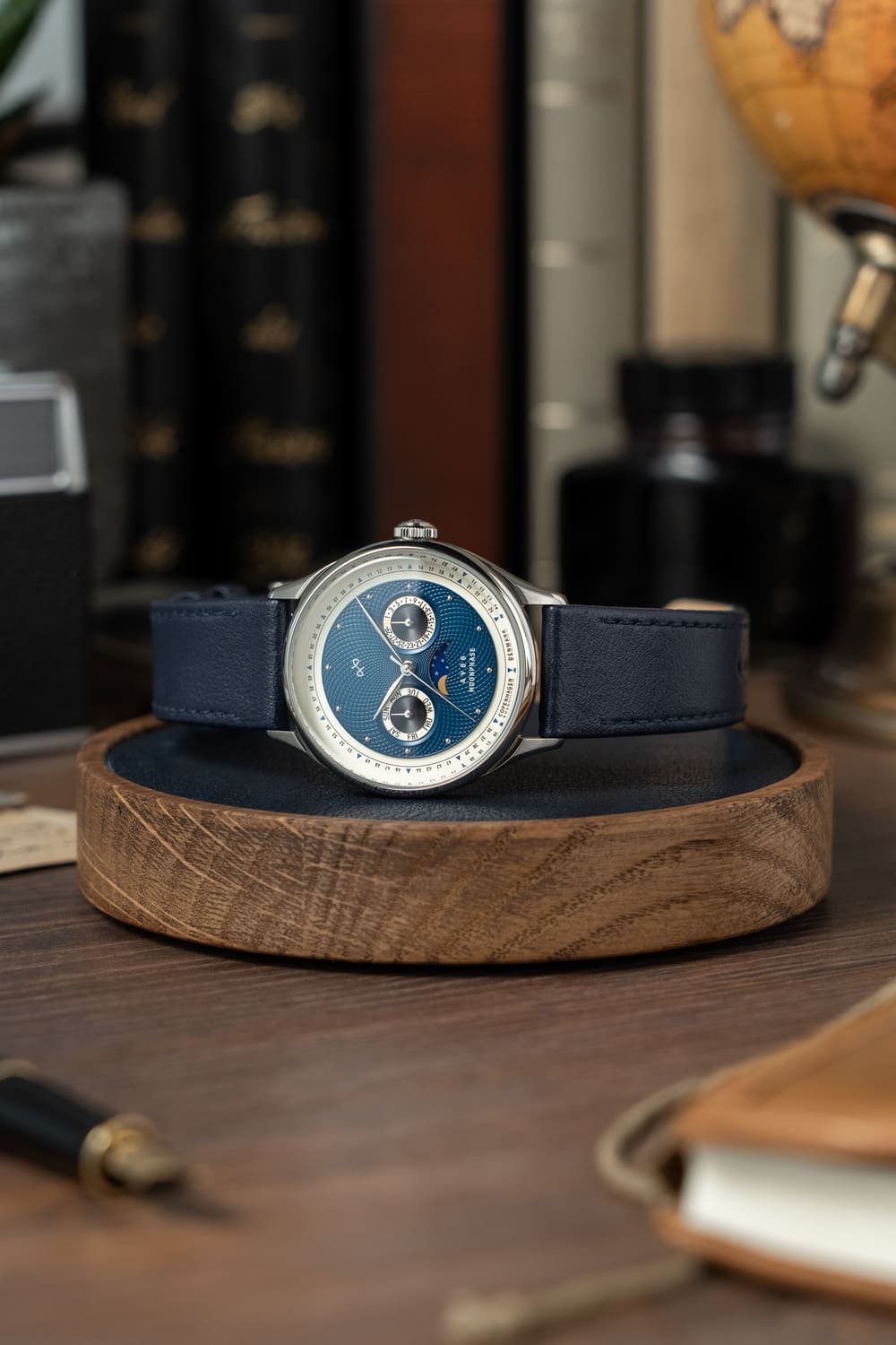1968 Moonphase by AV86 luxury moonphase watch with sapphire crystal, vintage-inspired dial, and dark leather strap on wooden stand