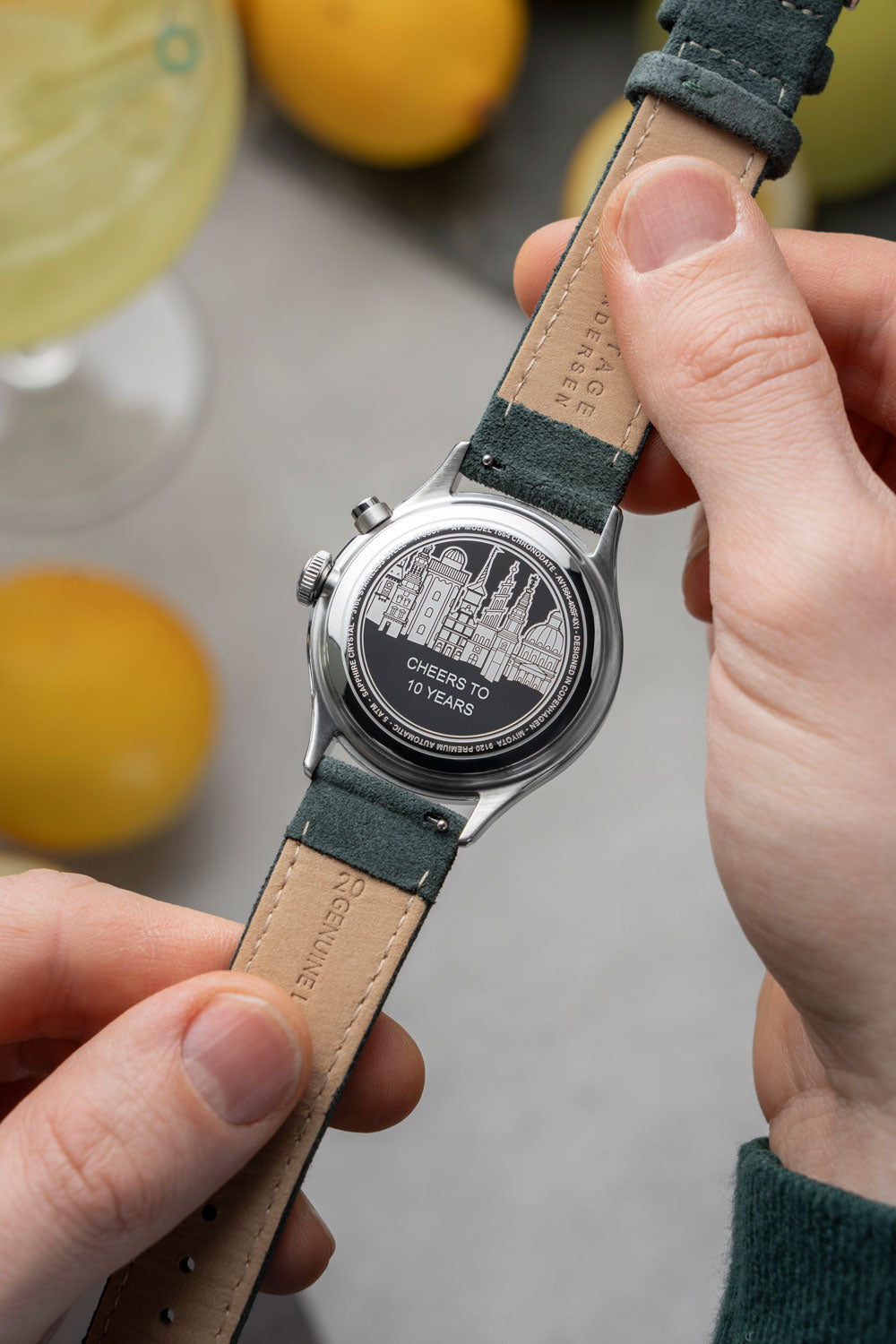 Close-up of engraving on the back of an AV86 chronograph watch celebrating 10 years with leather strap and detailed skyline design