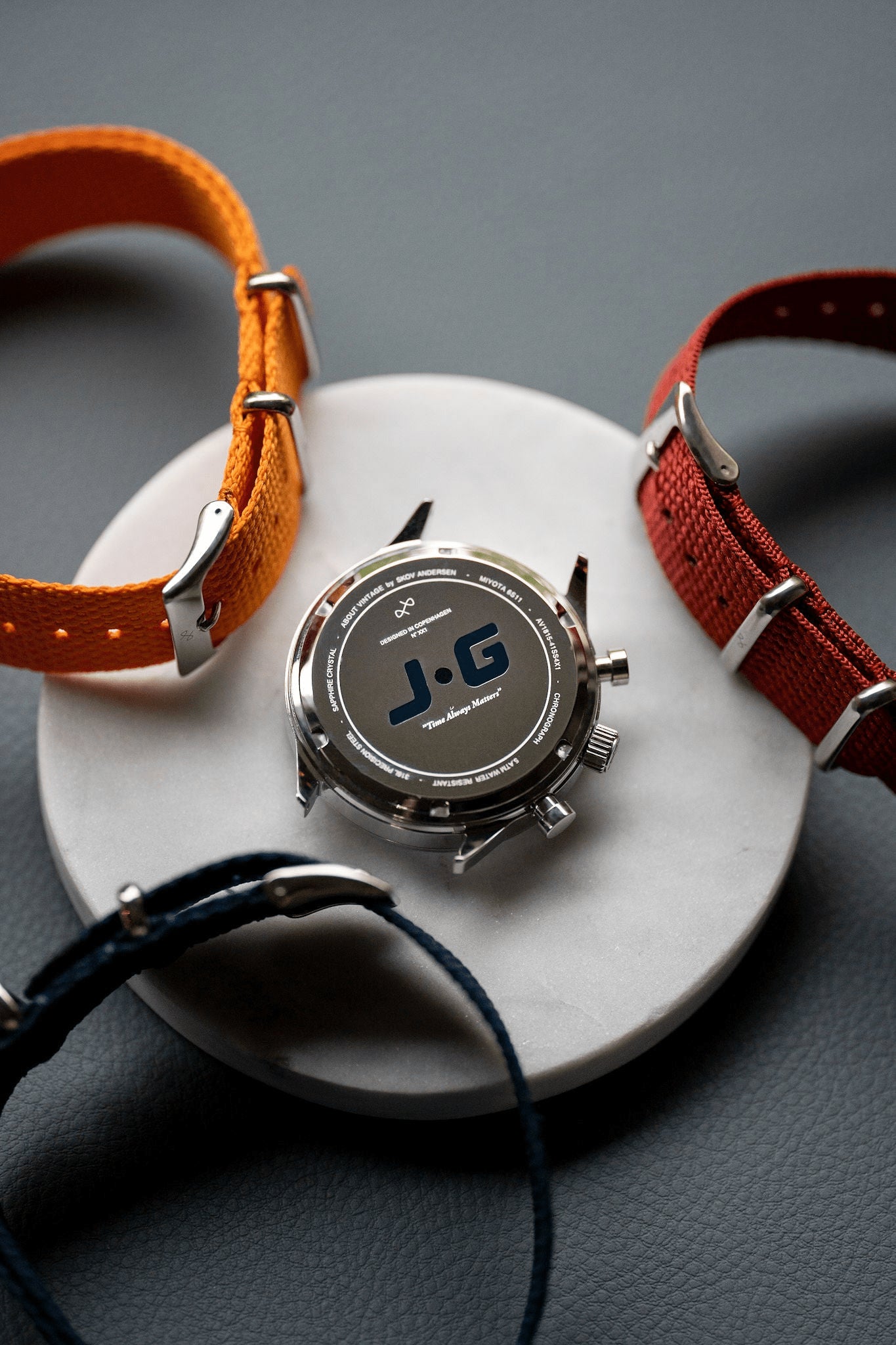 1815 Justin Gatlin, Gold / Blue Turtle by AV86 chronograph case back alongside interchangeable fabric NATO straps in orange, red, and blue